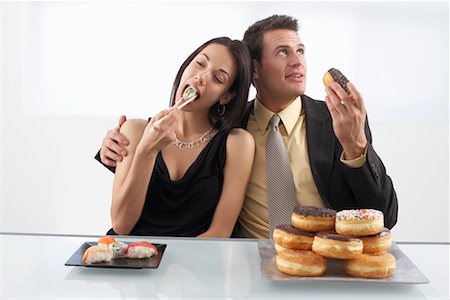 Woman Eating Sushi and Man Eating Doughnuts Stock Photo - Premium Royalty-Free, Code: 600-02201165