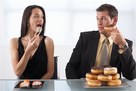 swedish spanish - Woman Eating Sushi and Man Eating Doughnuts Stock Photo - Premium Royalty-Free, Code: 600-02201162