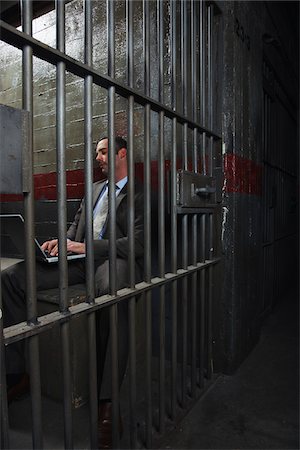 Man Using Laptop in Jail Stock Photo - Premium Royalty-Free, Code: 600-02201320