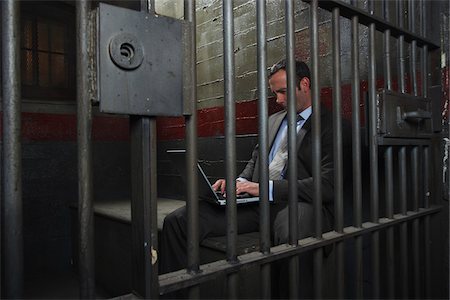 Man Using Laptop in Jail Stock Photo - Premium Royalty-Free, Code: 600-02201321