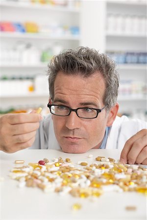 pharmacist (male) - Pharmacist Looking at Pile of Pills Stock Photo - Premium Royalty-Free, Code: 600-02245613