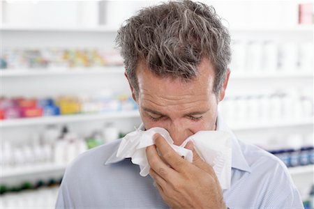 sneeze cold - Man in Pharmacy Blowing Nose Stock Photo - Premium Royalty-Free, Code: 600-02245664