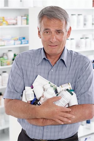 Portrait of Man in Pharmacy Carrying a Pile of Pill Bottles Foto de stock - Sin royalties Premium, Código: 600-02245667