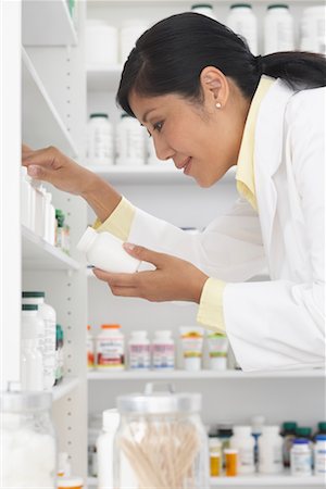 simsearch:600-02265323,k - Pharmacist Looking at Pills on Shelf Stock Photo - Premium Royalty-Free, Code: 600-02265336