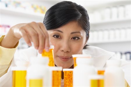 Portrait of Pharmacist Looking at Pill Bottles Stock Photo - Premium Royalty-Free, Code: 600-02265337