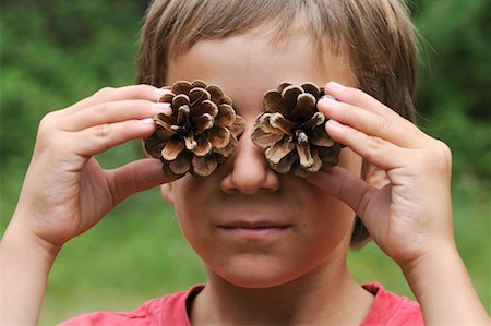 simsearch:600-02290116,k - Boy with Pine Cones in Front of Eyes Fotografie stock - Premium Royalty-Free, Codice: 600-02290117