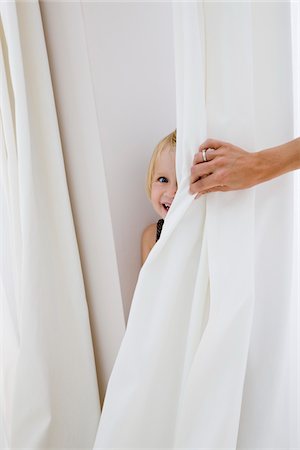 people peeking curtain - Little Girl Playing Hide and Seek Stock Photo - Premium Royalty-Free, Code: 600-02332646