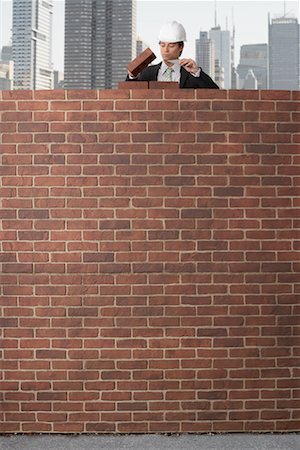 skyscraper construction - Businessman Building a Brick Wall Stock Photo - Premium Royalty-Free, Code: 600-02346316