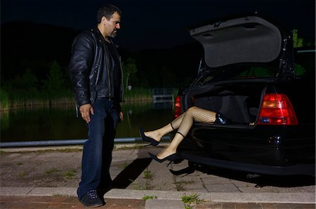 Man Looking at Dead Body in Trunk of Car Stock Photo - Premium Royalty-Free, Code: 600-02348072