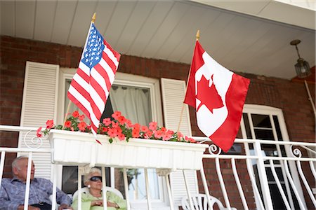 simsearch:600-07540311,k - Couple senior sur le porche de l'avant avec des drapeaux américains et canadiens Photographie de stock - Premium Libres de Droits, Code: 600-02377071