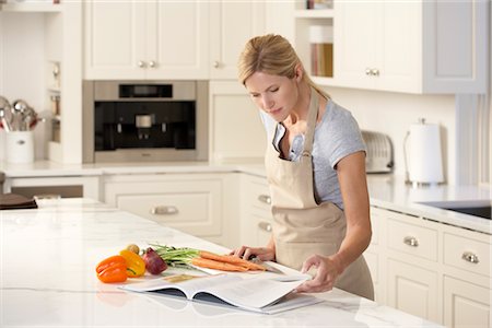 simsearch:600-03738408,k - Woman Reading Cookbook in Kitchen Stock Photo - Premium Royalty-Free, Code: 600-02428912