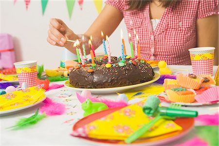 Woman Lighting Candles on Birthday Cake Fotografie stock - Premium Royalty-Free, Codice: 600-02461266