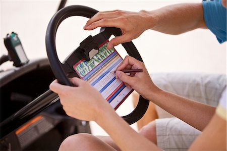 photo of card playing woman - Couple Marking Score Card in Golf Cart Stock Photo - Premium Royalty-Free, Code: 600-02670415