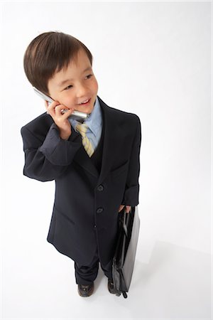 simsearch:600-02693682,k - Little Boy Dressed Up as a Businessman Talking on Cell Phone Foto de stock - Royalty Free Premium, Número: 600-02693719