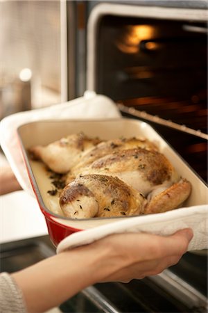 simsearch:600-02701254,k - Woman Taking Roast Chicken out of Oven Foto de stock - Sin royalties Premium, Código: 600-02701254