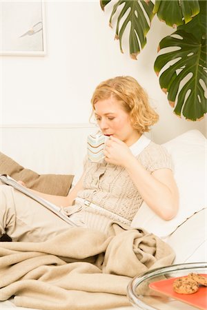 Frau sitzt auf dem Sofa lesen Stockbilder - Premium RF Lizenzfrei, Bildnummer: 600-02756435