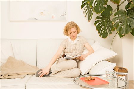 Femme assise sur le lecture de divan Photographie de stock - Premium Libres de Droits, Code: 600-02756431