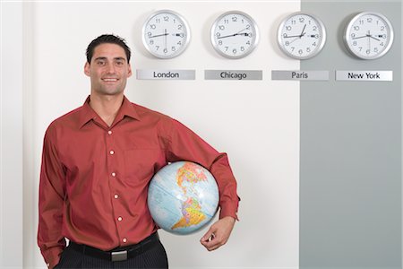 Businessman Holding Globe Standing by Clocks Showing International Time Zones Foto de stock - Sin royalties Premium, Código: 600-02757036