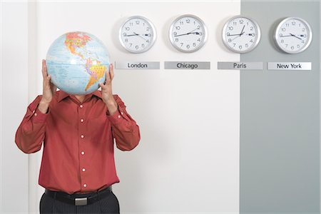 Homme d'affaires tenant le Globe permanent par des horloges montrant les fuseaux horaires internationaux Photographie de stock - Premium Libres de Droits, Code: 600-02757037