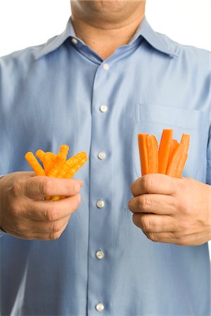 Man Holding Cheesies in One Hand and Carrot Sticks in the Other Stock Photo - Premium Royalty-Free, Code: 600-02757041
