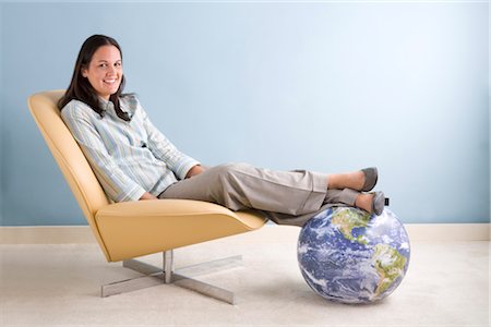 Businesswoman Sitting With Her Feet on a Globe Foto de stock - Sin royalties Premium, Código: 600-02757065