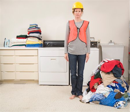 Woman Wearing Safety Vest and Hard Hat Doing the Laundry Stock Photo - Premium Royalty-Free, Code: 600-02757061