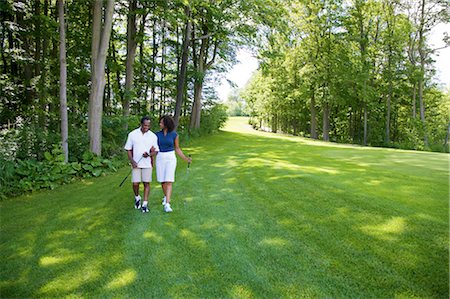 simsearch:600-02751507,k - Couple Walking on Golf Course Fotografie stock - Premium Royalty-Free, Codice: 600-02751509