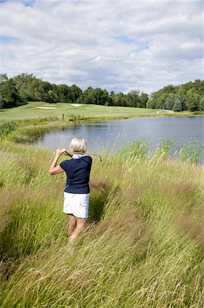 simsearch:600-02751507,k - Back View of Woman Golfing in Tall Grass Fotografie stock - Premium Royalty-Free, Codice: 600-02751527