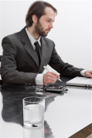 Tablets Dissolving in Glass of Water on Businessman's Desk Stock Photo - Premium Royalty-Free, Code: 600-02798115