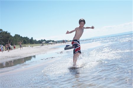 Boy Skimboarding at Deanlea Beach, Elmvale, Ontario, Canada Stock Photo - Premium Royalty-Free, Code: 600-02887094