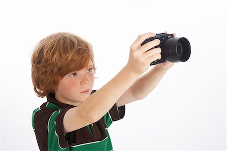 person in white polo shirt - Boy Holding Camera Stock Photo - Premium Royalty-Free, Code: 600-02912764