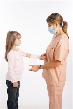 Nurse Wrapping Bandage Around Girl's Arm Stock Photo - Premium Royalty-Free, Code: 600-02912823