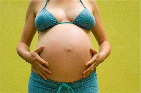 expansion (accroissement de volume) - Femme, enceinte de neuf mois touchant son ventre Photographie de stock - Premium Libres de Droits, Code: 600-02922769