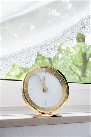 round window - Clock on a Window Sill Stock Photo - Premium Royalty-Free, Code: 600-03069325