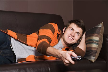single man on the couch watching tv - Man Watching Television Stock Photo - Premium Royalty-Free, Code: 600-03075170