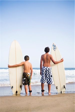 rear view boy swimsuit - Garçons détenant des planches de surf Photographie de stock - Premium Libres de Droits, Code: 600-03171577