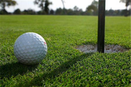 pelota de golf - Close-up of Golf Ball Beside Hole Foto de stock - Sin royalties Premium, Código: 600-03171631