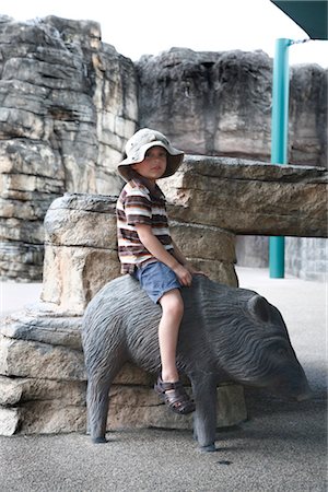 Boy Sitting on Statue of Boar Foto de stock - Sin royalties Premium, Código: 600-03195017