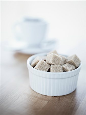 Bowl of Raw Sugar Cubes, Cup of Coffee in the Background Foto de stock - Sin royalties Premium, Código: 600-03230258