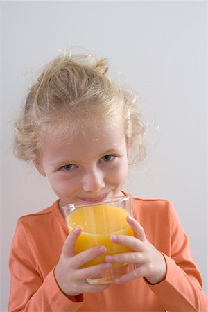 simsearch:600-03368370,k - Petite fille à boire un verre de jus d'Orange Photographie de stock - Premium Libres de Droits, Code: 600-03244487