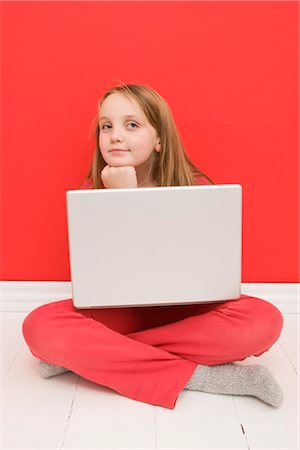 Portrait of Girl Sitting on Floor using Laptop Computer Stock Photo - Premium Royalty-Free, Code: 600-03240857