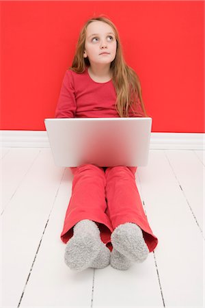 Girl Sitting on Floor using Laptop Computer Stock Photo - Premium Royalty-Free, Code: 600-03240859