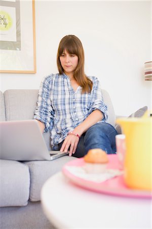 Woman Sitting on Sofa using Laptop Computer Stock Photo - Premium Royalty-Free, Code: 600-03298867