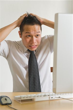 defeat - Businessman Pulling his Hair in front of Desktop Computer Stock Photo - Premium Royalty-Free, Code: 600-03333289