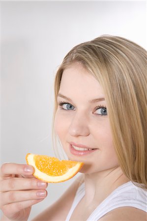 Woman Eating Slice of Orange Stock Photo - Premium Royalty-Free, Code: 600-03404070