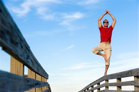 Homme en équilibre sur la balustrade en bois, Honeymoon Island, Floride, Etats-Unis Photographie de stock - Premium Libres de Droits, Code: 600-03439274
