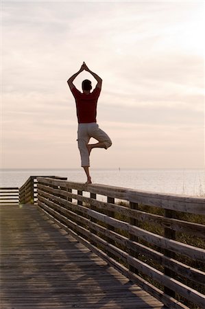 sunrise man back - Man Balancing on Wooden Railing, Honeymoon Island, Florida, USA Stock Photo - Premium Royalty-Free, Code: 600-03439275