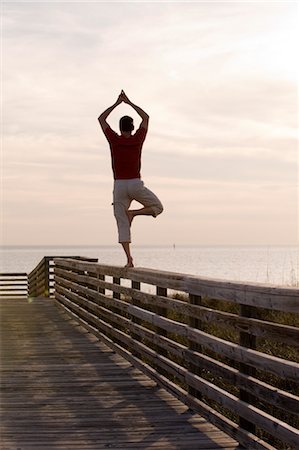 sunset in florida - Man Balancing on Wooden Railing, Honeymoon Island, Florida, USA Stock Photo - Premium Royalty-Free, Code: 600-03439275