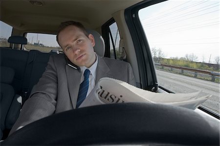 driver (car, male) - Driver Talking on Cell Phone and Reading Newspaper Stock Photo - Premium Royalty-Free, Code: 600-03445835