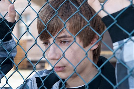 Close-Up of Boy Behind Fence Foto de stock - Sin royalties Premium, Código: 600-03456206